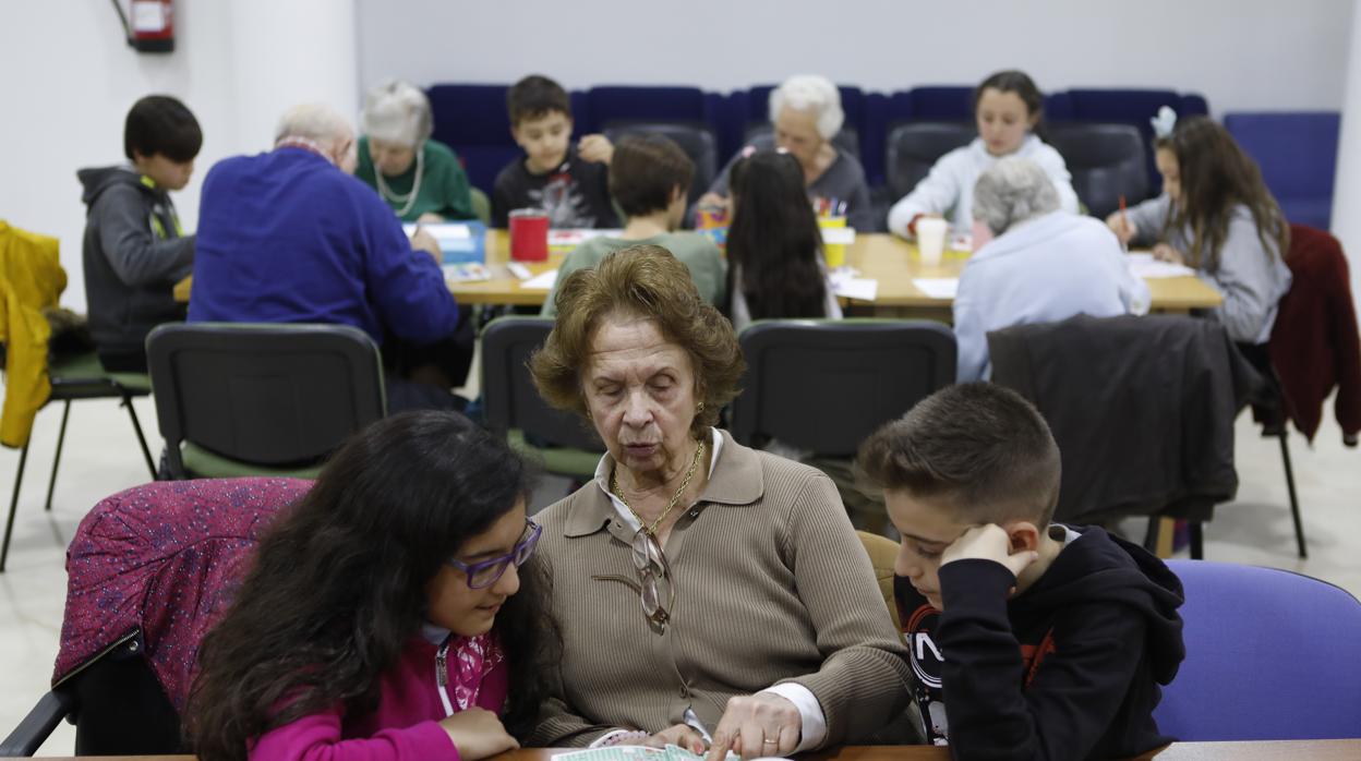 Dos niños junto a una mujer en el centro de alzheimer San Rafael de Córdoba