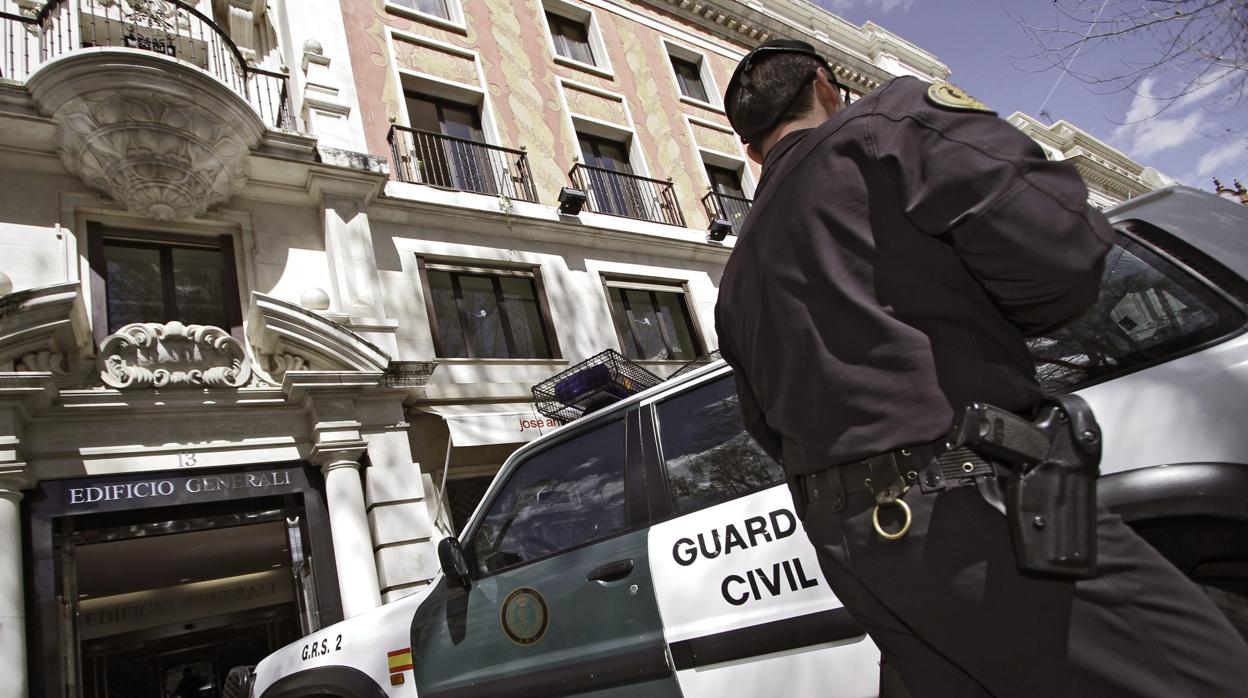 Un agente junto a un furgón de la Guardia Civil durante una redada en Sevilla