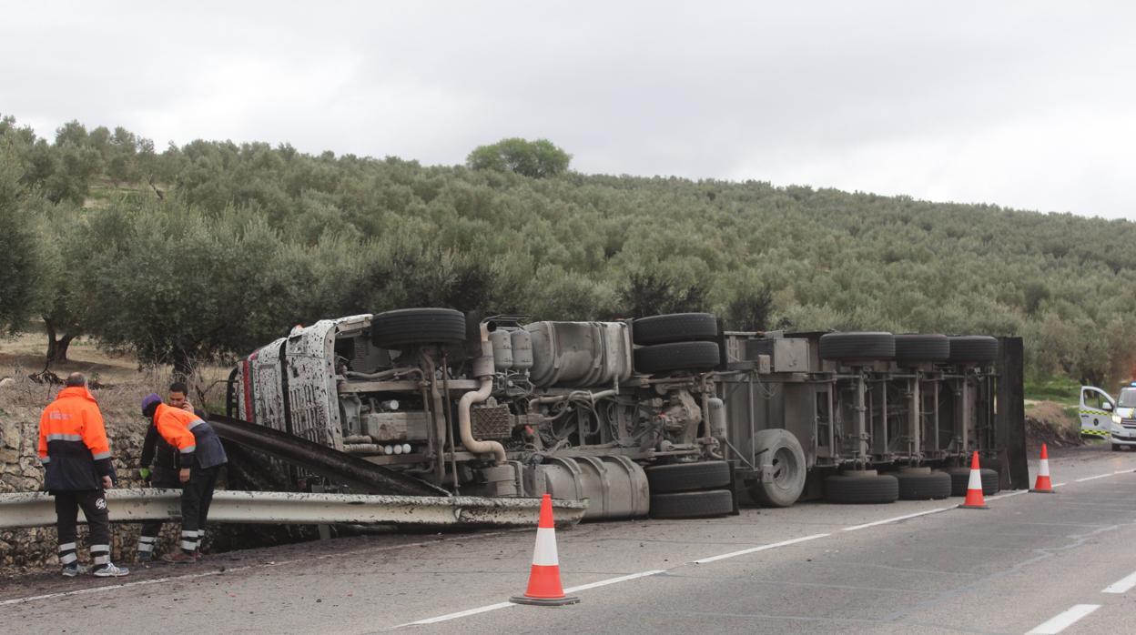 Operarios con el camión volcado