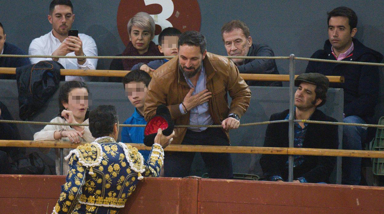 El presidente de VOX, Santiago Abascal, en los tendidos de la plaza de toros de Vistalaegre, junto al diestro Morante de la Puebla, recoge un brindis de El Cid