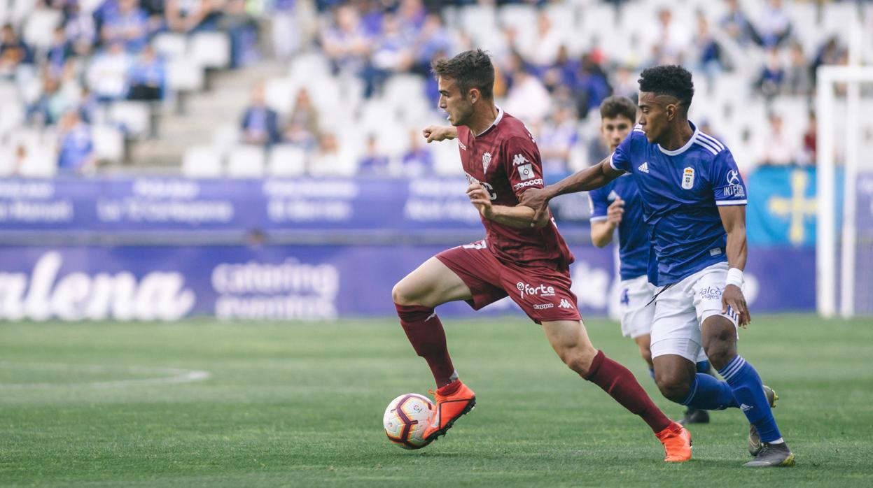 Álex Carbonell conduce el balón perseguido por Yoel Bárcenas en el Real Oviedo-Córdoba CF