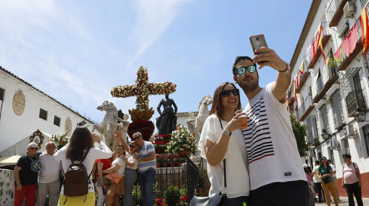 Una pareja se fotografía con la Cruz de Mayo de la Plaza de Santa Marina