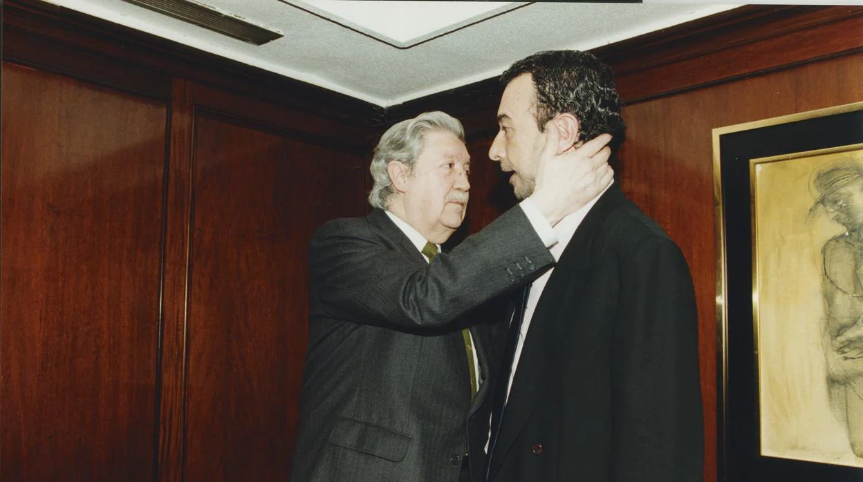 Manuel Alcántara abraza a José Luis Garci en 1998, durante la presentación del libro «Vuelta de hoja»