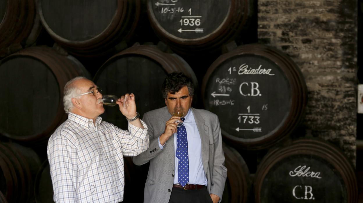 Uno de los responsables de Bodegas Alvear catando un vino junto un grupo de soleras