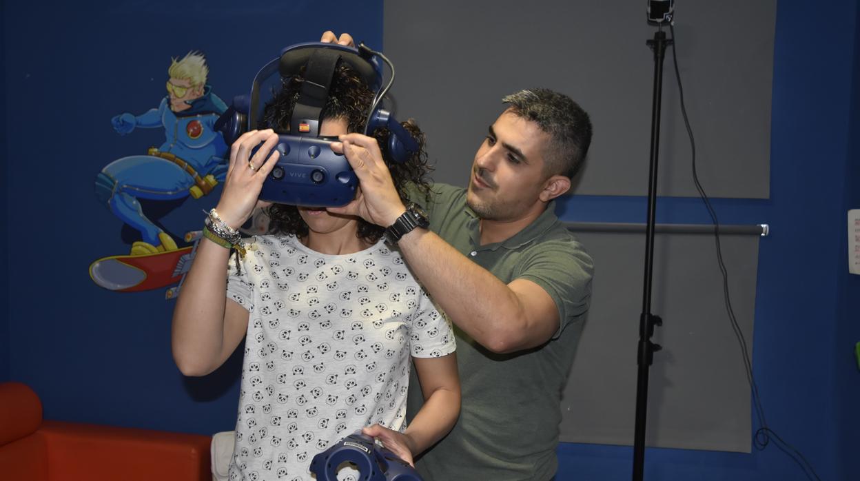 Uno de los promotores de la iniciaitiva con una niña en el Hospital usando las gafas de realidad virtual