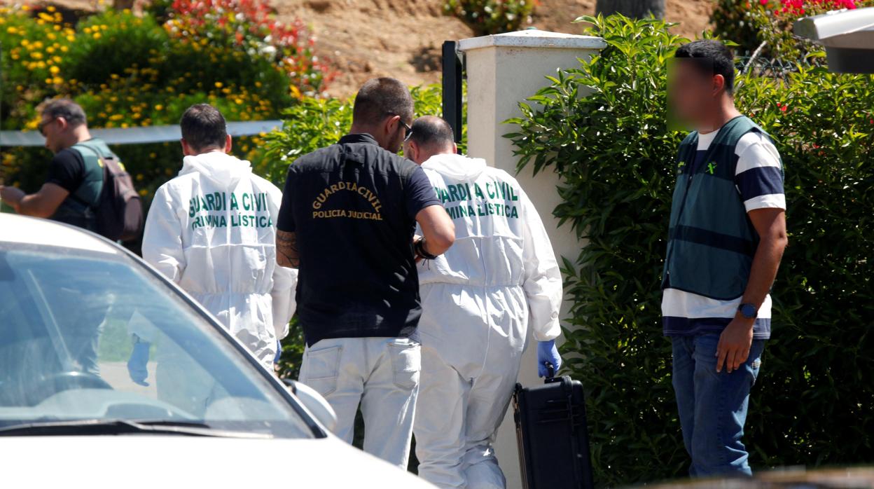 Agentes de criminalística e investigadores de la Guardia Civil en la puerta de la vivienda en Ayamonte