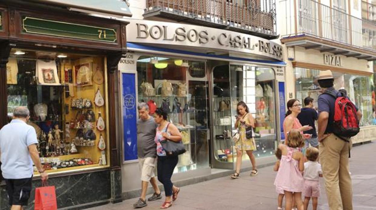 Calle comercial del centro de Sevilla con las tiendas abiertas