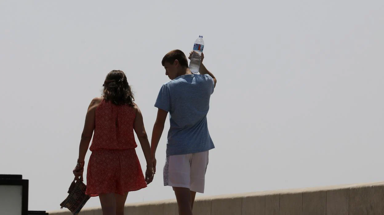 Una pareja pasea por el Puente Romano un día de calor