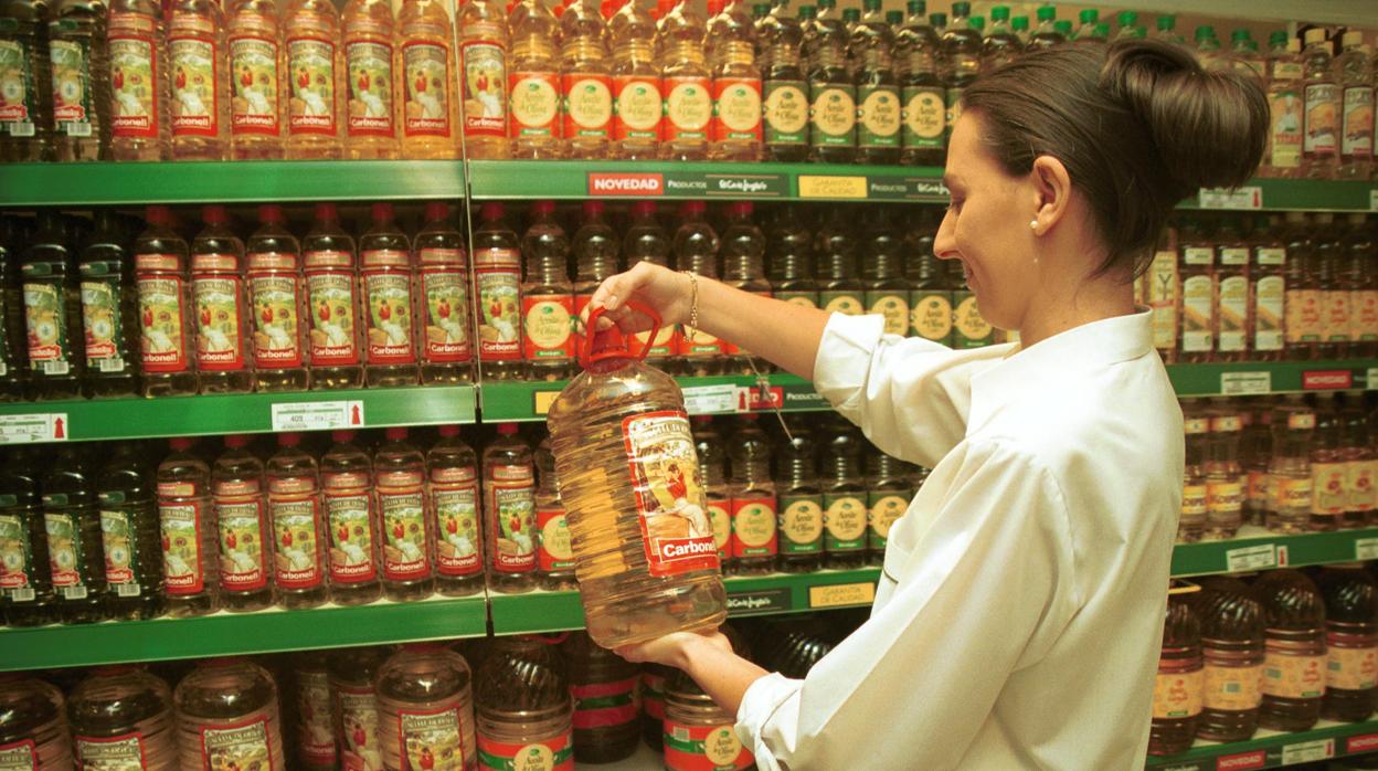 Una clienta observa una garrafa de aceite en un supermercado