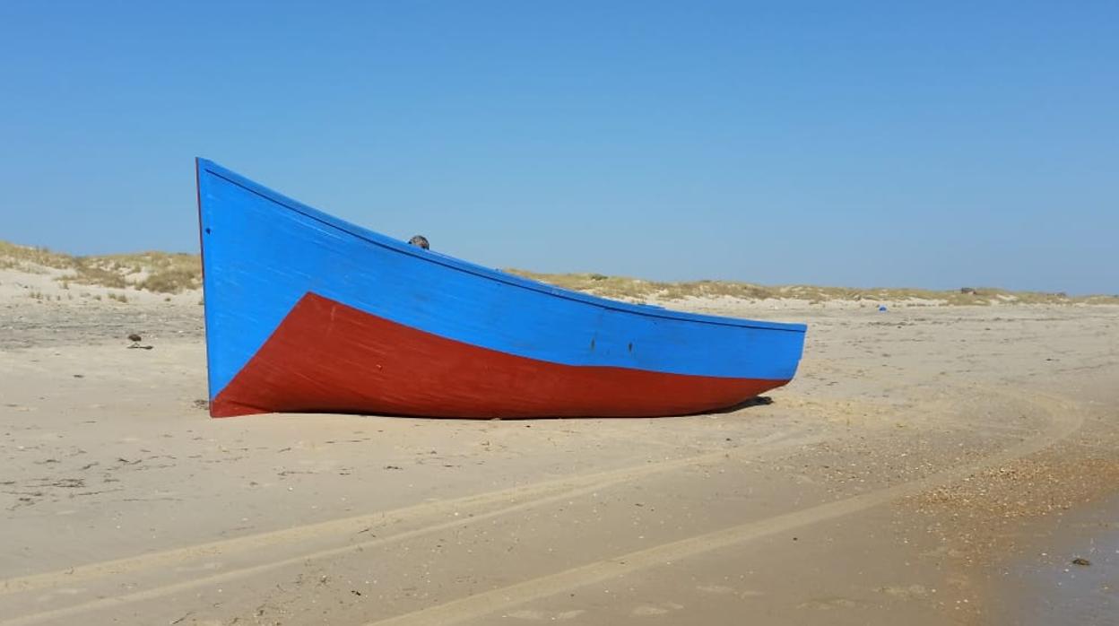 La patera encallada en la costa de Matalascañas a mediodía de este domingo