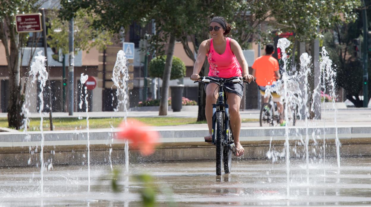 Una cordobesa se refresca en una fuente pública en ver