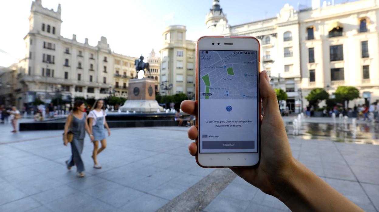 Un usuario muestra la aplicación de Uber en las Tendillas