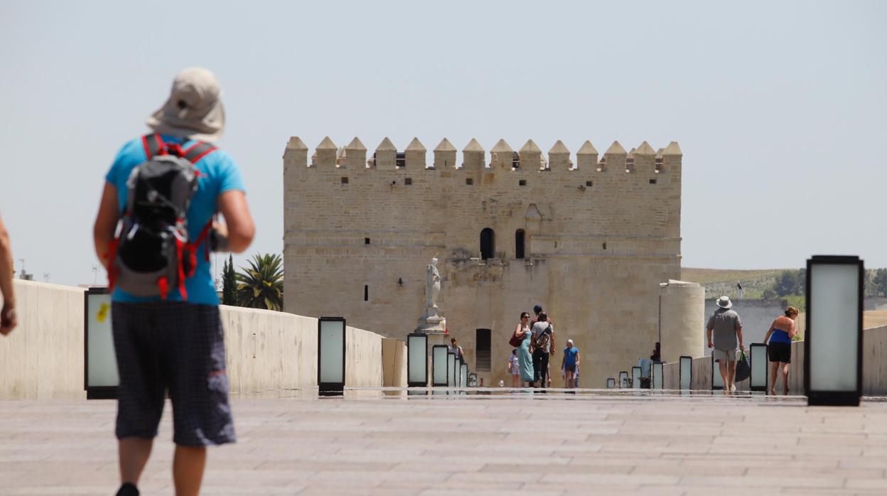 Un turista pasea por el Puente Romano en un día de calor