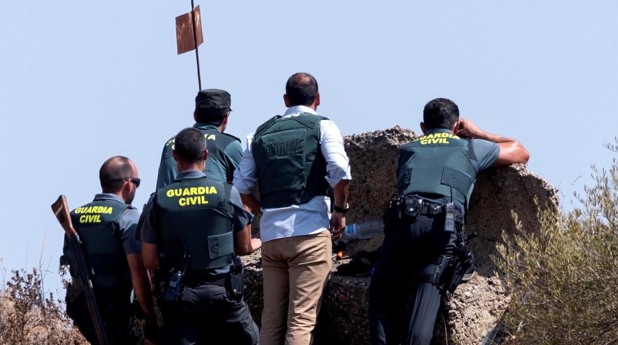 Miembros de la Guardia Civil se proetgen del hombre atrincherado portando una escopeta