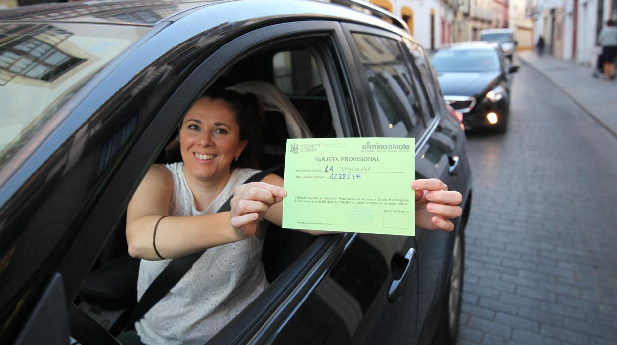 Una mujer muestra su tarjeta de autorización para acceder al centro