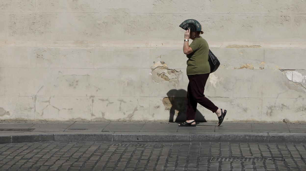 Una mujer se protege del calor en una calle de Córdoba