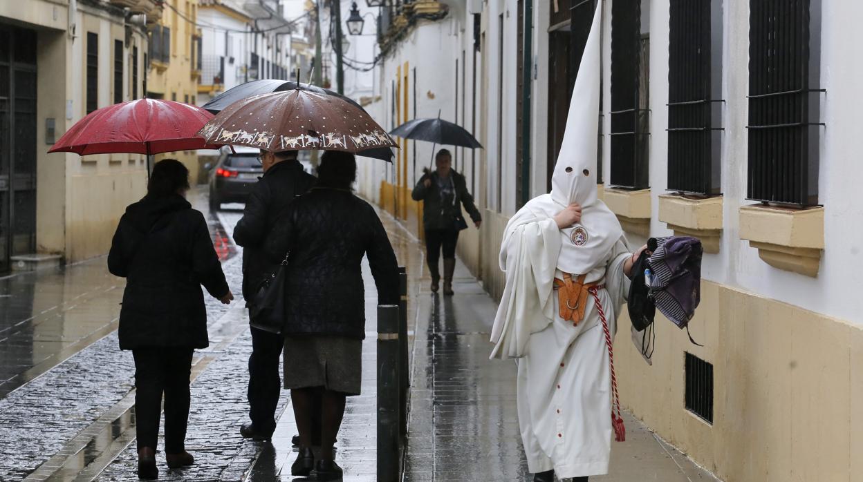 Un nazareno de la Borriquita tras la suspensión por lluvia en 2018