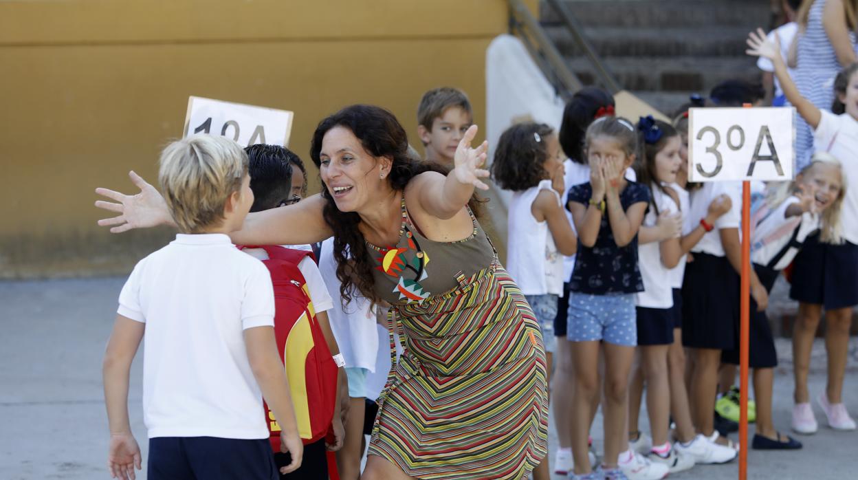 Una profesora recibe con los brazos abiertos a uno de sus alumnos