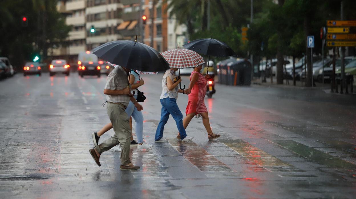 Un grupo de personas huye de la lluvia en el centro de Córdoba