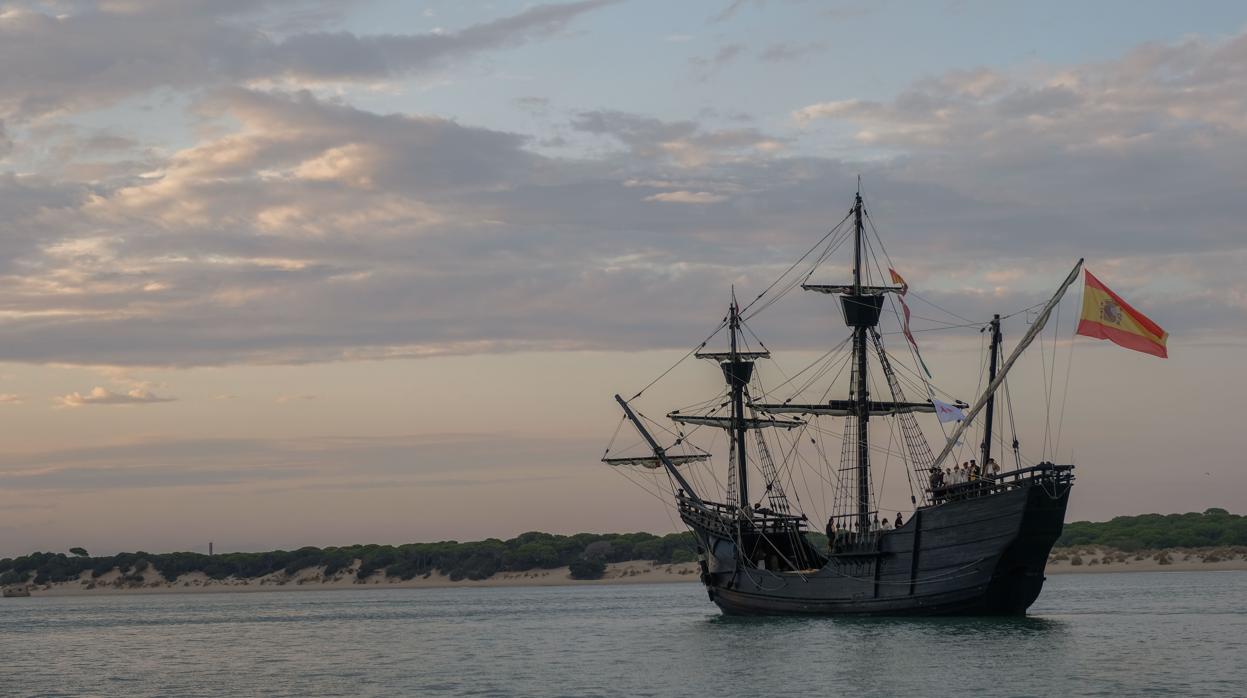 Imagen del atardecer en Sanlúcar con la réplica de la embarcación que circunnavegó el mundo a la derecha