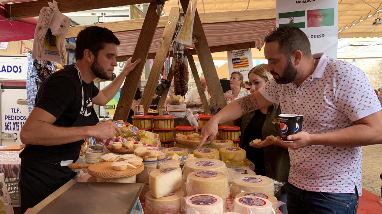 Un quesero atiende a uno de los visitantes de la Fiesta del Queso