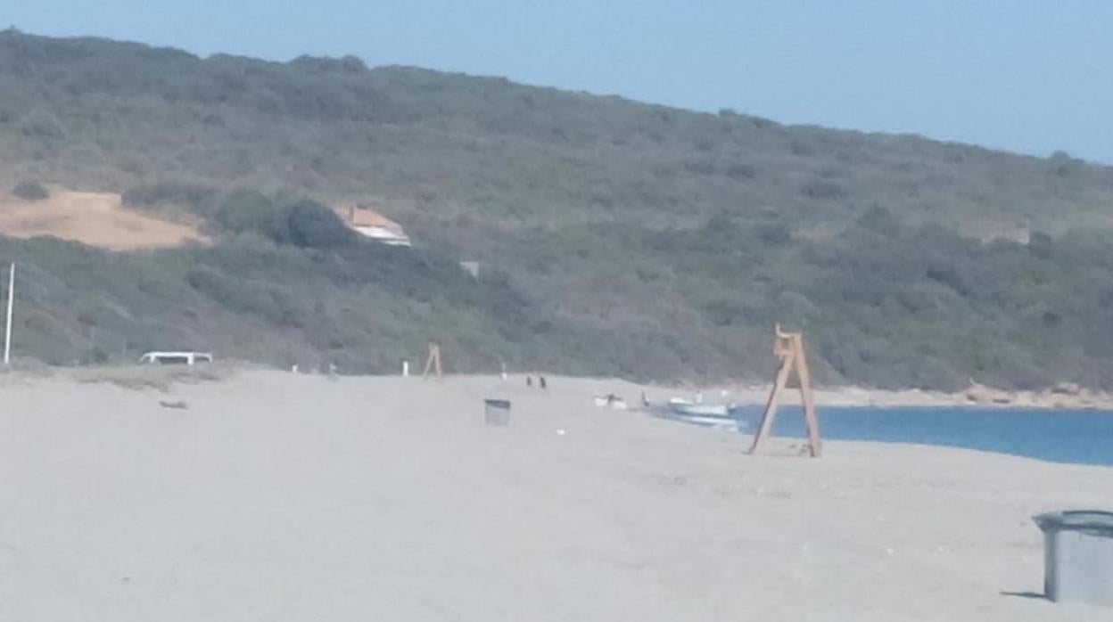 Al fondo, el vehículo, los porteadores y la embarcación, este jueves en una playa de San Roque