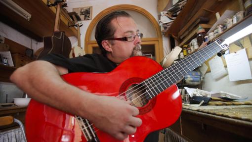 Jaime Aragón Peña prueba una guitarra ya terminada en su taller