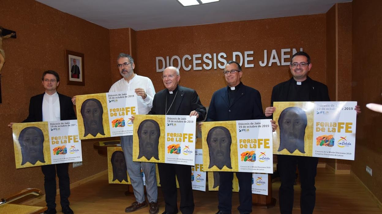 El obispo de Jaén, Amadeo Rodríguez Magro, en el centro, con el cartel que anuncia la feria de la Fe