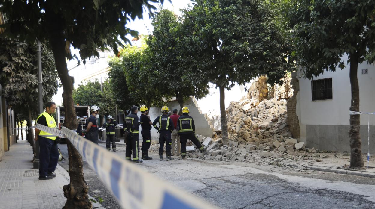 Los bomberos, ante el muro derrumbado en la calle San Fernando