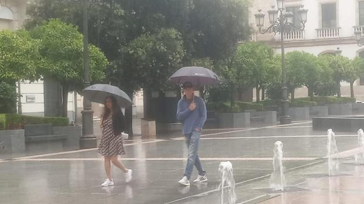 Dos personas en el centro de la ciudad bajo la lluvia