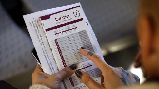 Una pasajera consulta la tabla de horarios