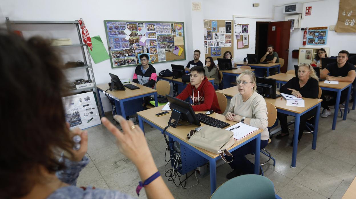 Una profesora imparte clase a adultos en el IES Averroes