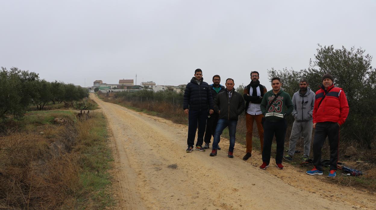 Vecinos junto al solar donde se hará la depuradora de Encinas Reales, con las viviendas al fondo