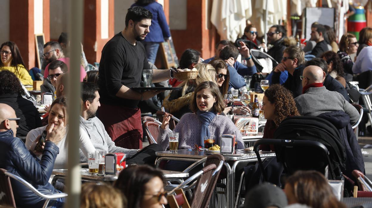 Un camarero atiende una mesa de uno de los negocios de hostelería de la plaza de la Corredera