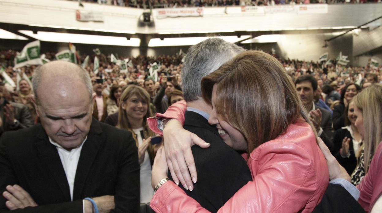 Susana Díaz se abraza a José Antonio Griñán, en presencia de Manuel Chaves en un acto del PSOE el Día de Andalucía de 2014