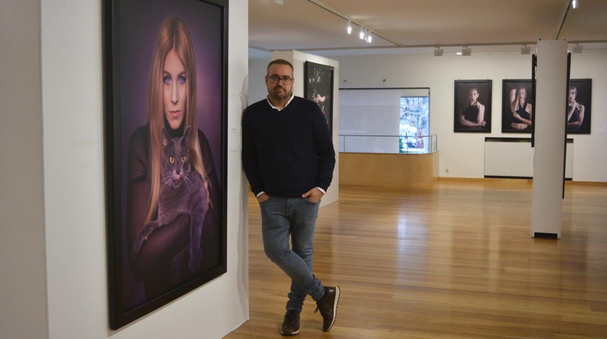 El periodista Jorge Pastor posa junto a una de sus fotografías en la exposición.