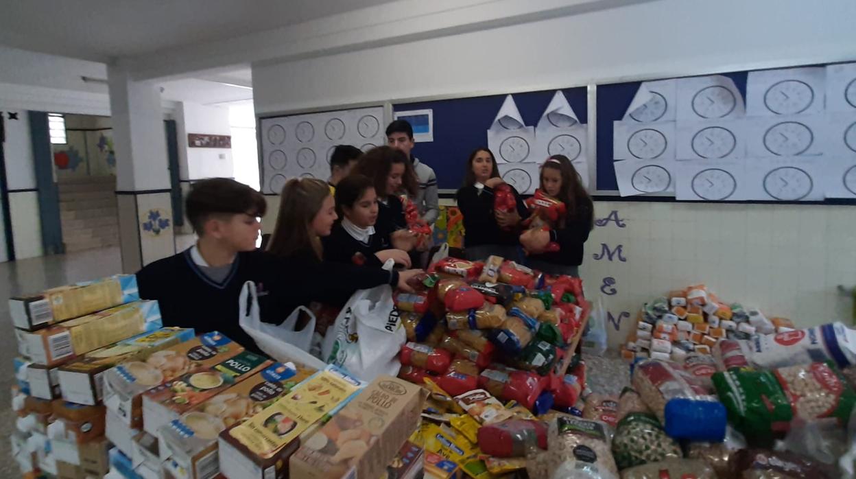 Alumnos agrupando los alimentos recogidos en las instalaciones del centro