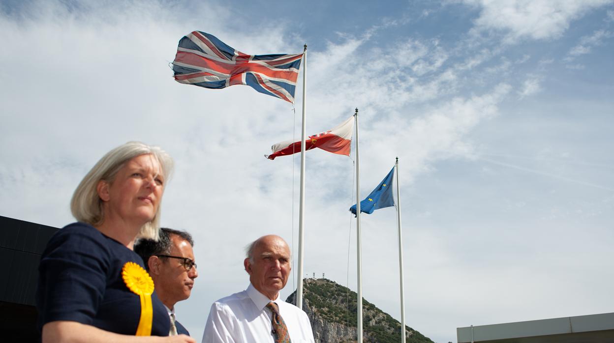 Las tres banderas que ondean en Gibraltar, en una foto de una visita de políticos británicos al Peñón