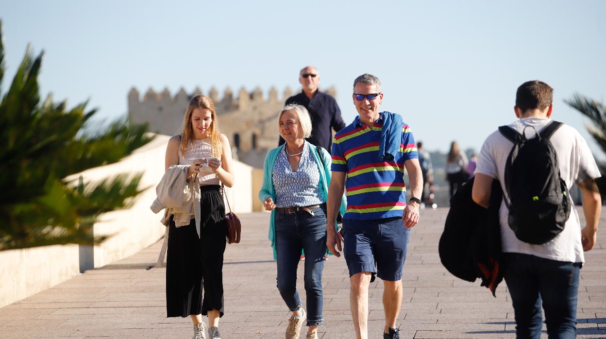 Turistas pasean por el Puente Romano un día de sol