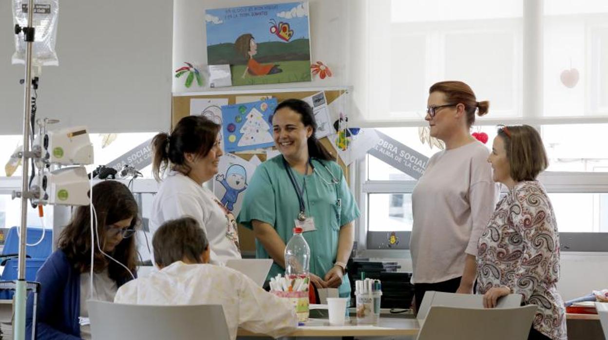 La doctora Gómez, en el centro, conversa con voluntarias, familiares y pacientes en el Reina Sofía