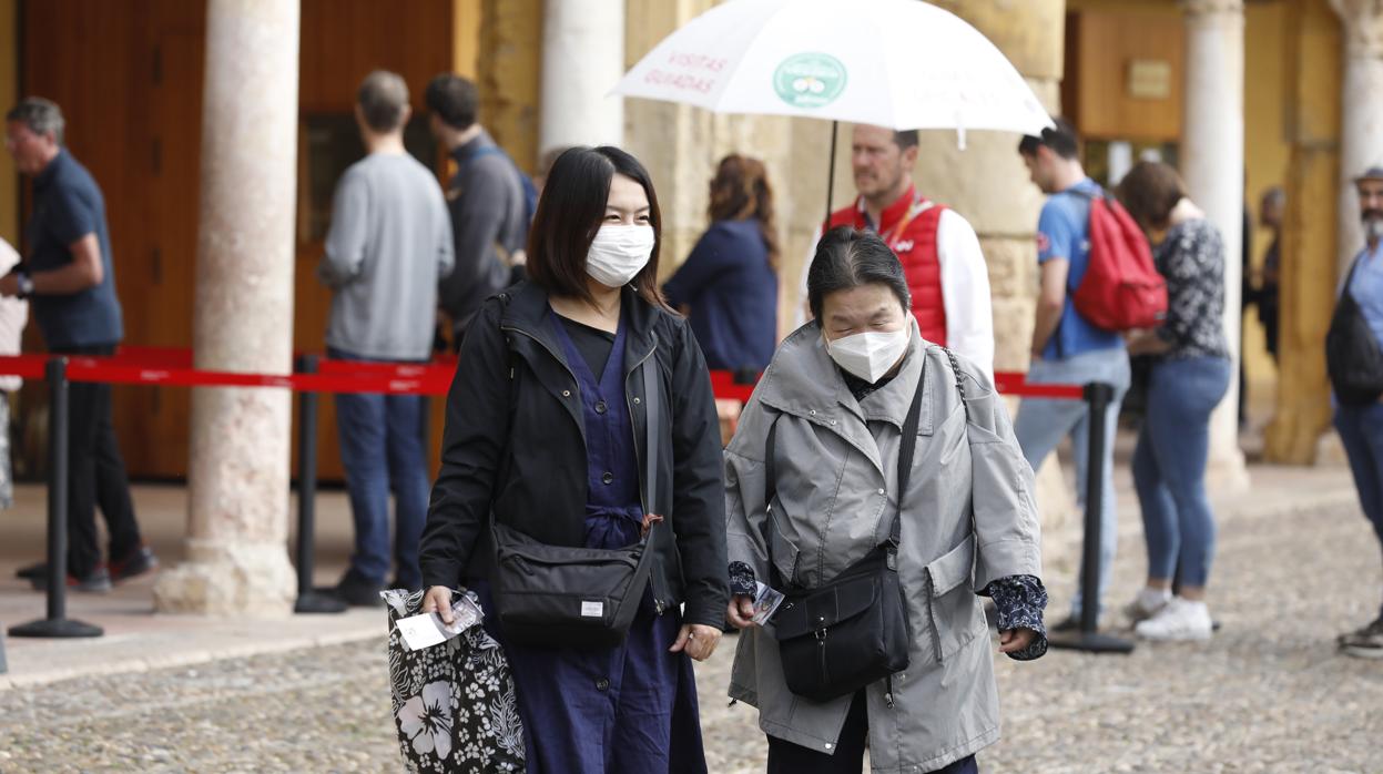 Turistas asiáticas, con mascarilla, hoy en el Patio de los Naranjos