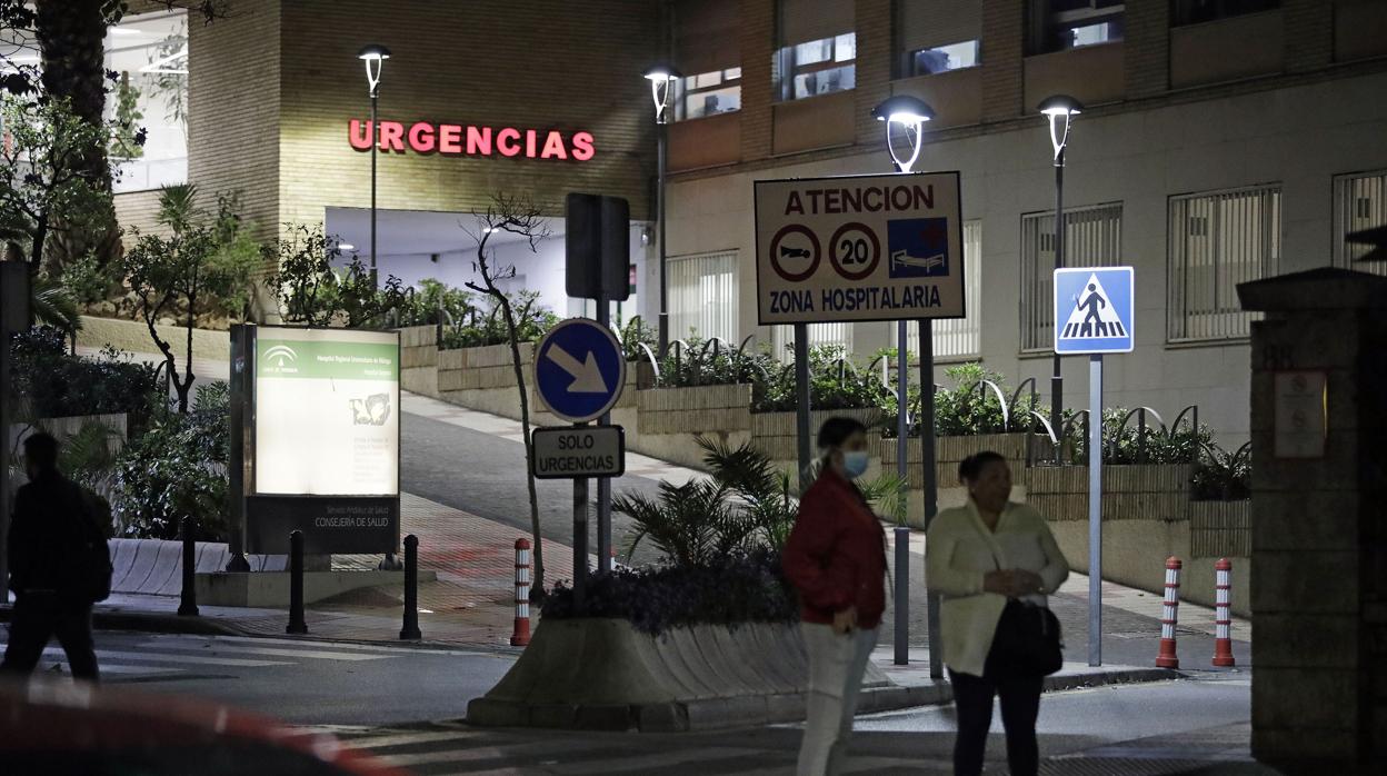 Dos mujeres con mascarillas esperan a la puerta del hospital Virgen del Rocío de Sevilla