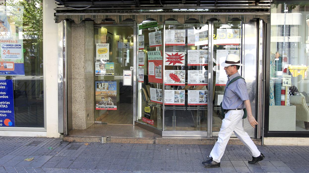 Un hombre pasa delante de una inmobiliaria de Córdoba