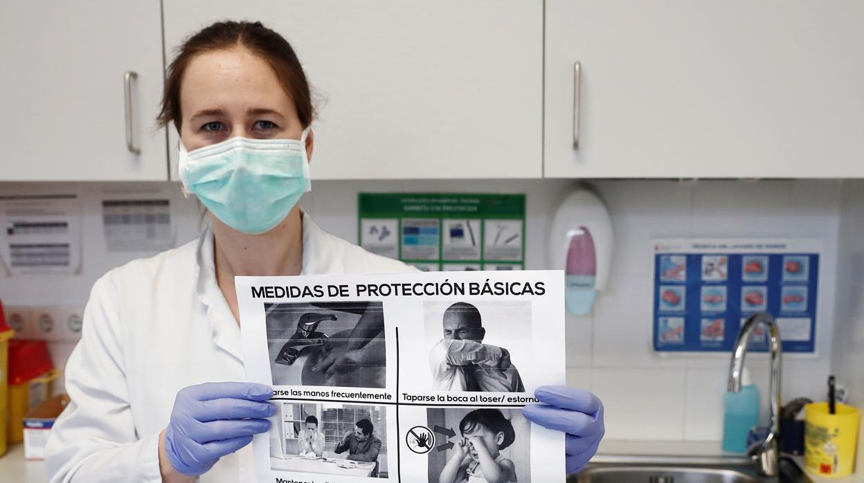 Una médico muestra un cartel con las medidas básicas de autoprotección