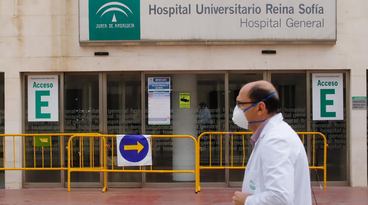 Un profesional sanitario pasa por delante de la fachada del Reina Sofía