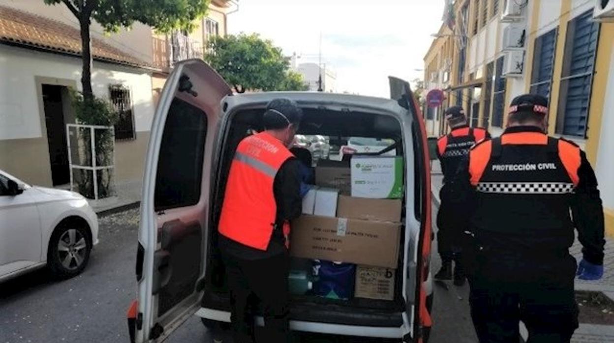 Voluntarios de Protección Civil recogiendo las cajas de material de los centros educativos