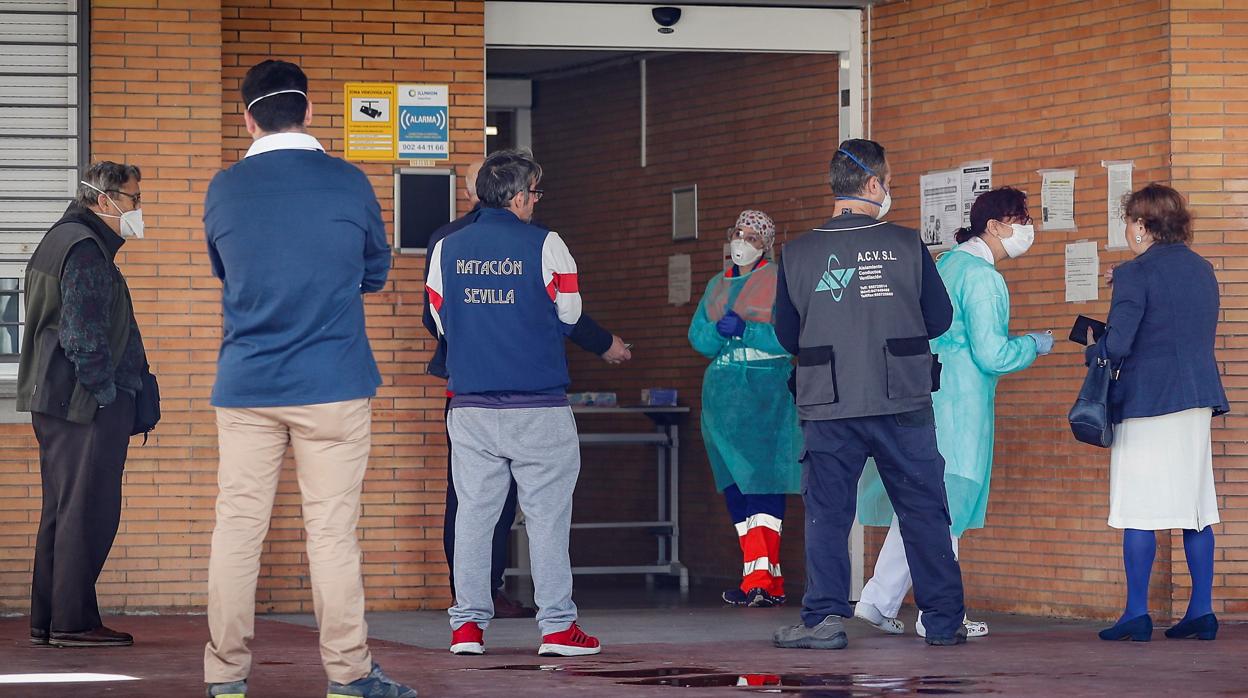 Pacientes y sanitarios en la puerta de un centro de salud de Mairena del Aljarafe, en Sevilla