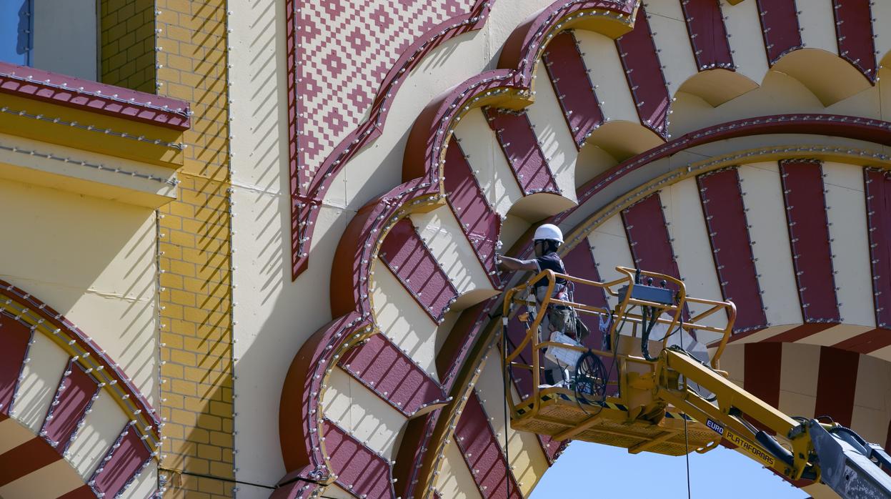 Un operario trabaja en el montaje de la portada de la Feria en la edición de 2019