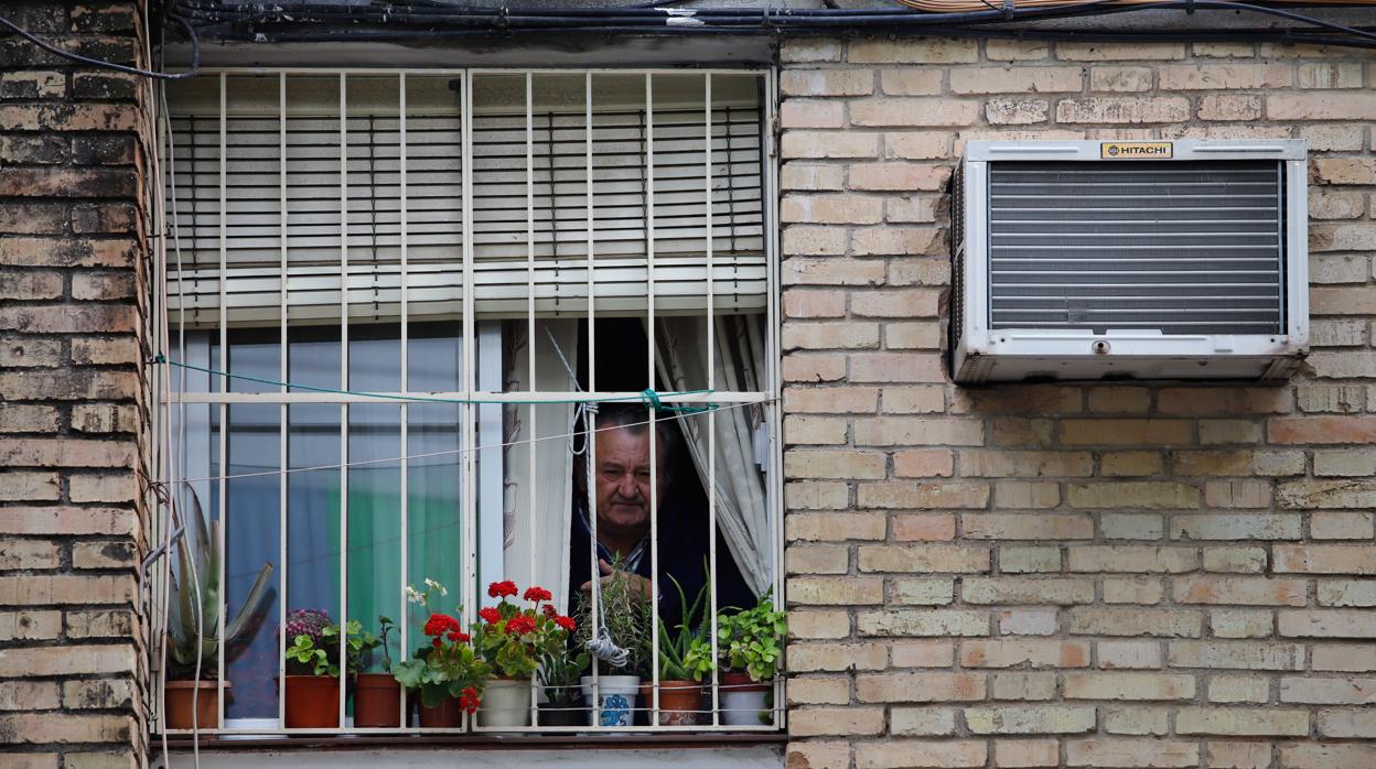 Un vecino mira por la ventana de un bloque cercano a la plaza del Mediodía