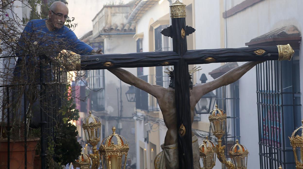 Un hombre toca la cruz del Cristo de la Misericordia